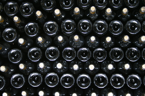 Pattern of lying stacked wine bottles in a wine cellar.