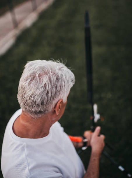istock One senior man aiming with bow and arrow 1249414404