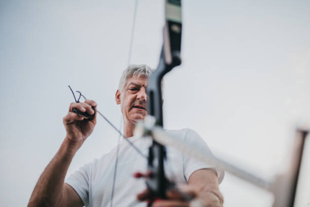 istock One senior man aiming with bow and arrow 1249416572