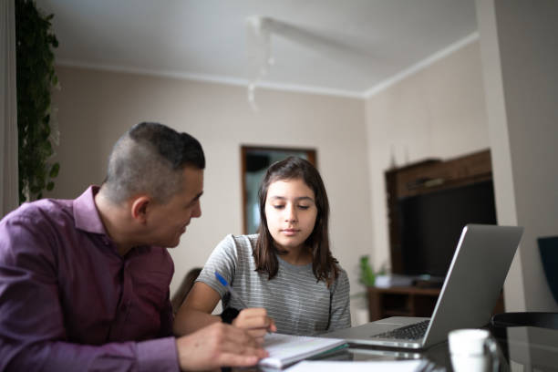 istock Father helping daughter studying using laptop at home 1249421561