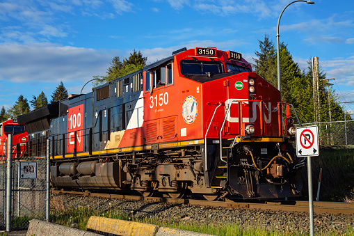 Prince Rupert, Canada - May 17, 2020. A CN Rail train approaches an intersection in Northern BC.