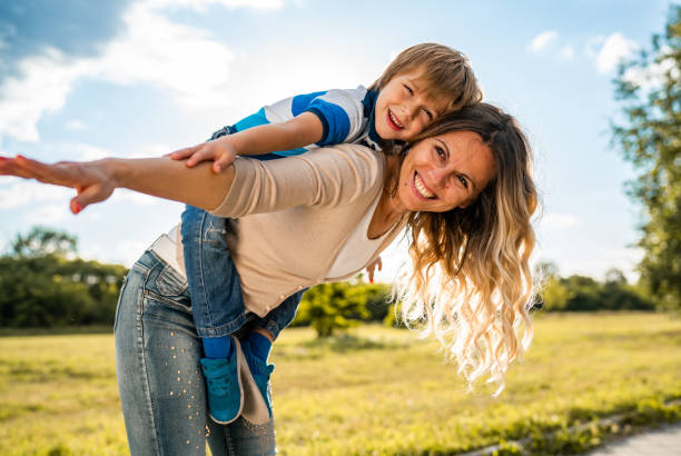 istock Happy mother is holding her son on back 1249438340