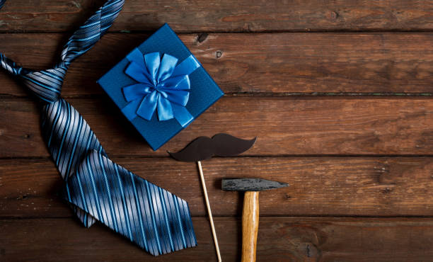 istock Happy Fathers Day gift box with tie on a rustic wood background. 1249440622