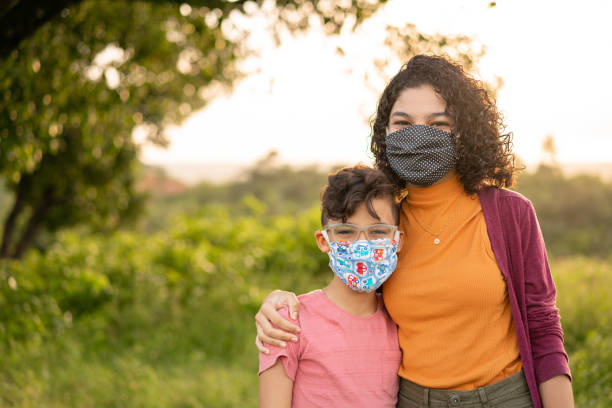 Children wearing N95 mask outdoors Children, Mask N95, Outdoors, Embracing, Family illness prevention photos stock pictures, royalty-free photos & images