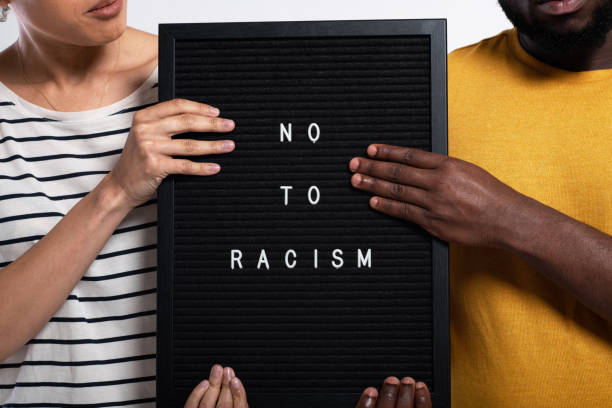 unrecognizable african-american couple posing in a studio with a sign "no to racism" - anti racism imagens e fotografias de stock