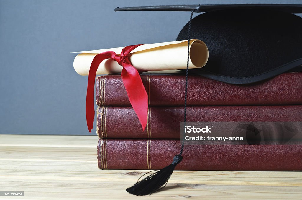 Toque de diplômé de remise des diplômes, faites défiler l'écran et livres - Photo de Diplôme libre de droits