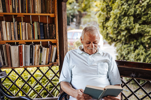 Senior man reading book in garden
