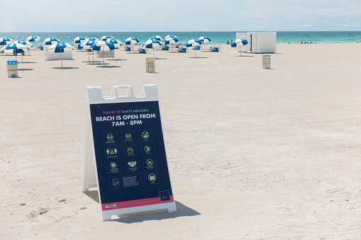 Miami Beach, FL USA -June 13, 2020 - A sign displays that the beach is now open along with new guidelines in place during the coroanvirus pandemic.