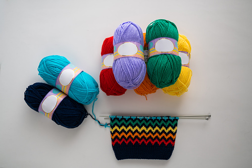 Close up on woman's hands knitting. Sitting on old armchair near window