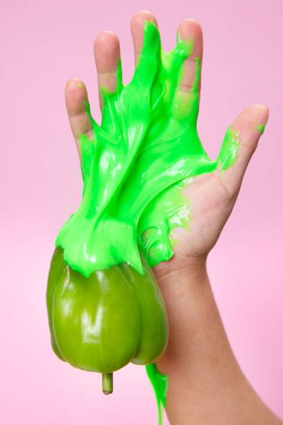 istock Hand Holding Sliced green Bell pepper on pink paper background. 1249450220