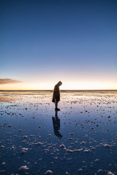 Man standing on his own reflection Man standing on his own reflection at Salt Flats in bolivia salar de uyuni stock pictures, royalty-free photos & images