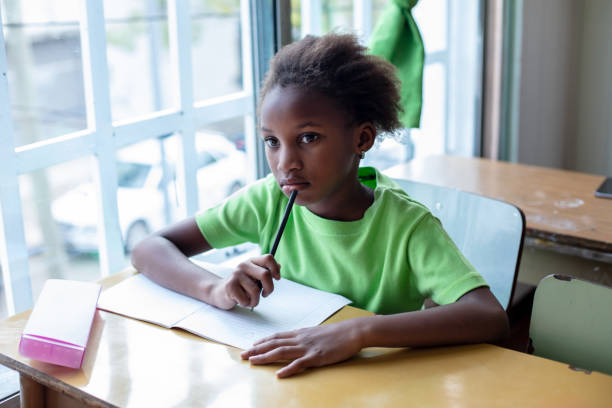 Beautiful black little girl paying attention during class at a rural school