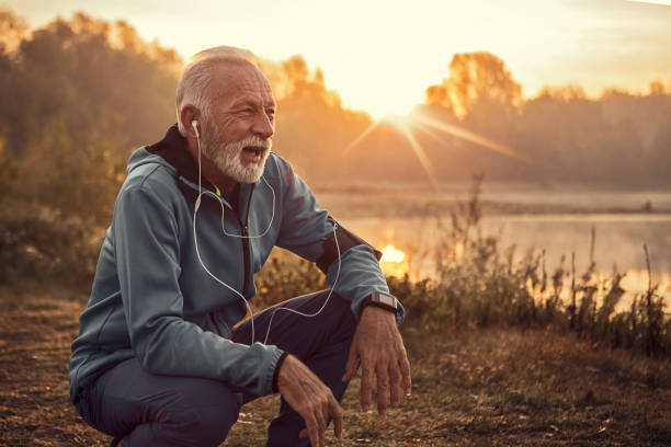 istock Mature man jogging in by lake with first sun ,resting 1249453611