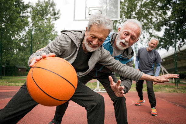 versuchen sie, den ball zu nehmen - senior adult exercising aging process instructor stock-fotos und bilder