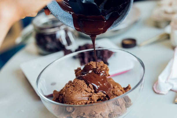 istock Anonymous Woman in an Apron Pouring Melted Dark Chocolate into Cookie Dough 1249455842
