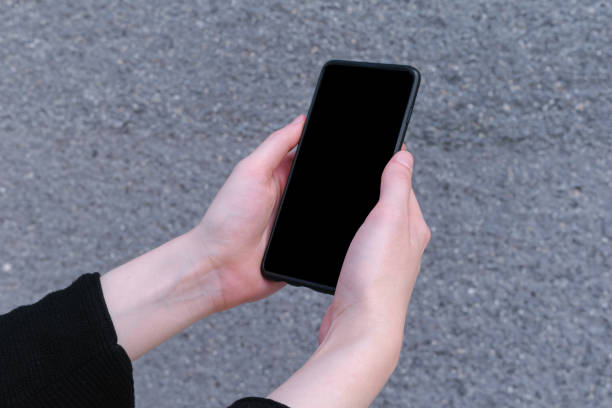 istock Woman holding modern smartphone with background, black mockup screen 1249456650