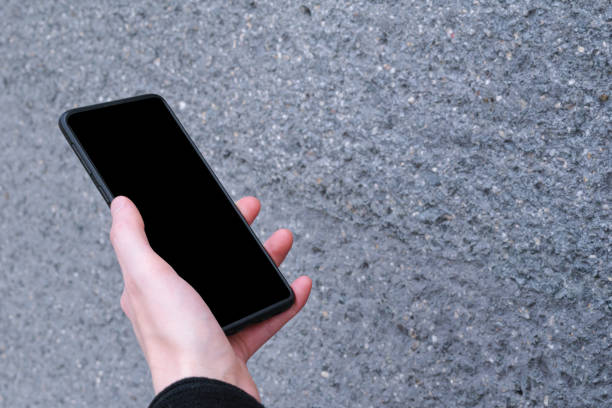 istock Woman holding modern smartphone with background, black mockup screen 1249457358