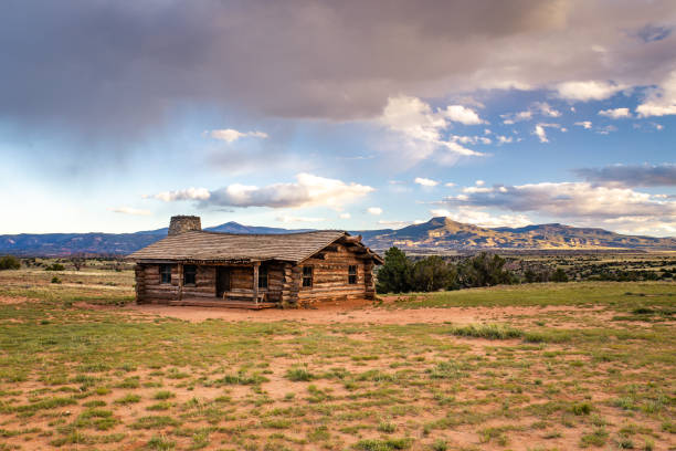 Low clouds hover over an old cabin on a plain near Abiquiu, New Mexico.