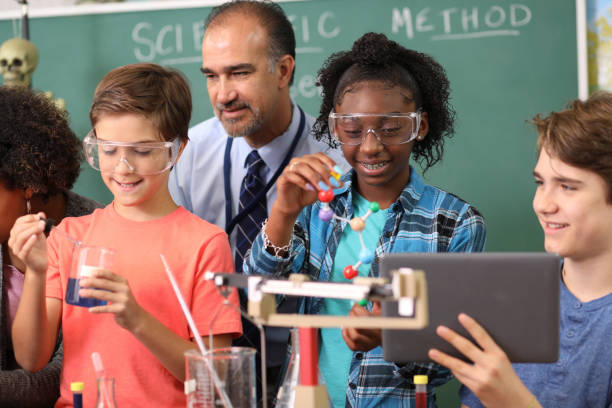 istock Junior high age school students conduct science experiments in classroom. 1249459597