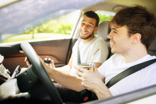 istock Two young men in a road trip driving a car and drinking yerba mate 1249461475