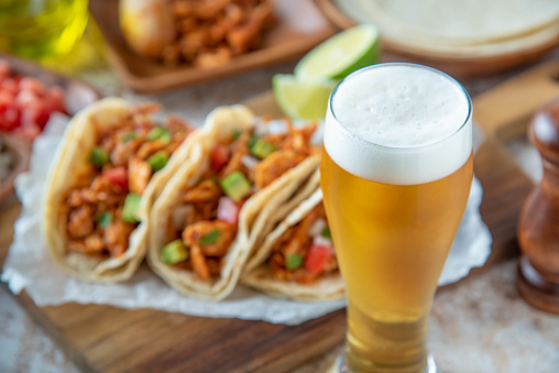 shredded chicken tacos with glass of beer