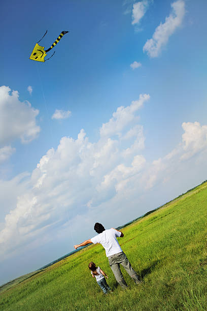 istock Little girl and her father with flying a kite 124946529