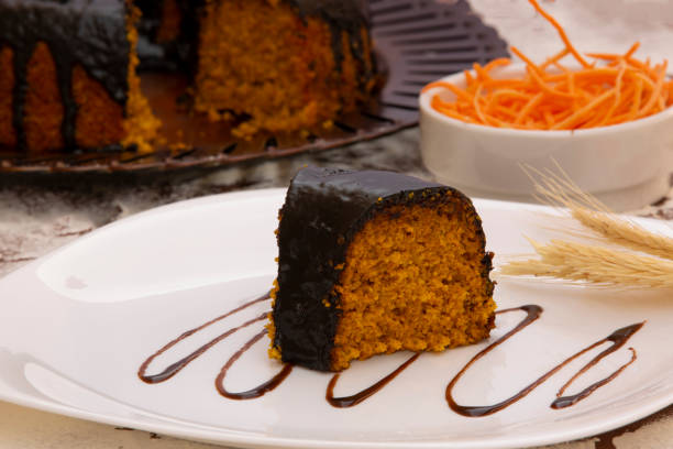 Carrot cake with chocolate and slice on the table, healthy cake with 70% cocoa topping. stock photo