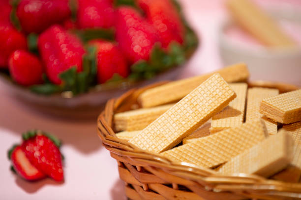 strawberry cream flavored wafer with blurred strawberries in the background. stock photo