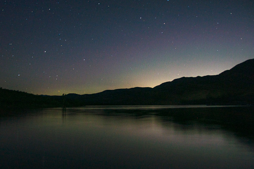 This long exposure shot was taken at night at the East Canyon State Park.   Some stars are visible above the mountain and lake surface but light pollution from nearby Salt Lake City prevents viewing the milky way and other prominent stars.