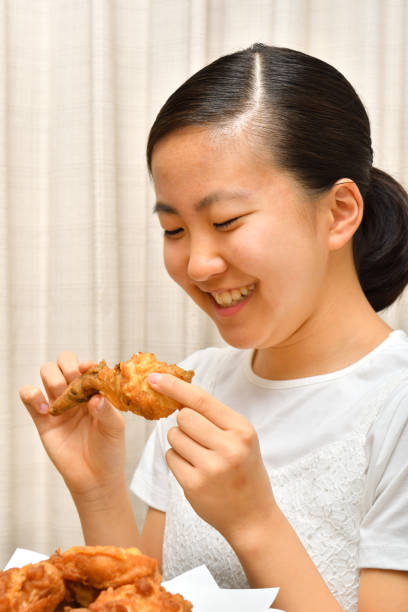 istock Japanese girl enjoys having fried chicken 1249477166