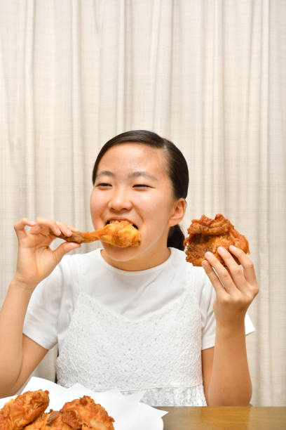 istock Japanese girl enjoys having fried chicken 1249477219