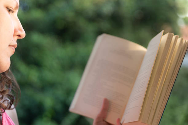 istock Close-up lady reading book green background 1249480727