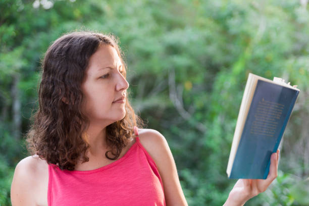 istock Environmentalist wearing pink reading book of climate change 1249482728