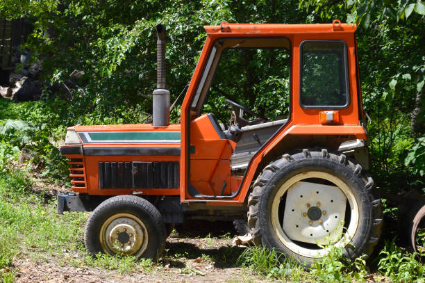istock Old orange tractor with no doors, with a pipe. Russian countryside 1249487685