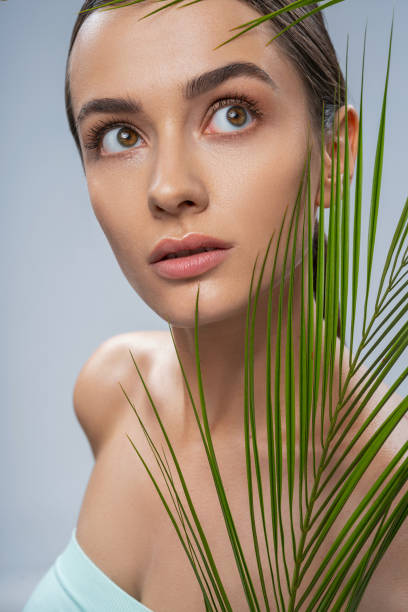 istock Relaxed beautiful woman with green palm leaf 1249488908