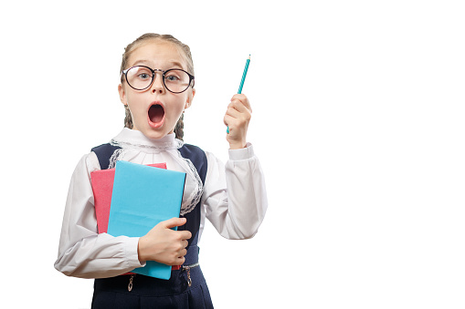 Smart Student Girl Hold Books Stack Look Surprised. Young Caucasian Beginner Dress Typical School Uniform on White Background. Learner Child in Glasses Keep Pencil in Hand Education Concept Copyspace