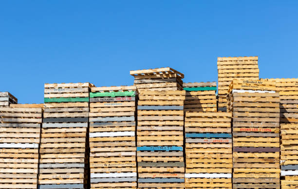 Perth, Australia - 2nd January, 2016: Wooden pallets stacked high with blue sky background. Some brands and logos visible on side of pallets