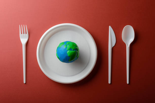 istock Serving table with Earth planet, plastic plate, spoon, fork and knife. Ecology Concept for Earth Hour, Earth Day, Ocean Day and other ECO dates. 1249495852