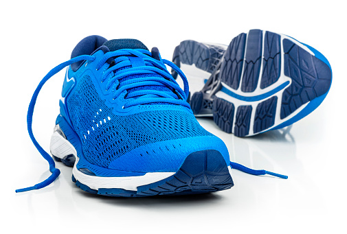 A pair of blue running shoes. \nIsolated on a white background.
