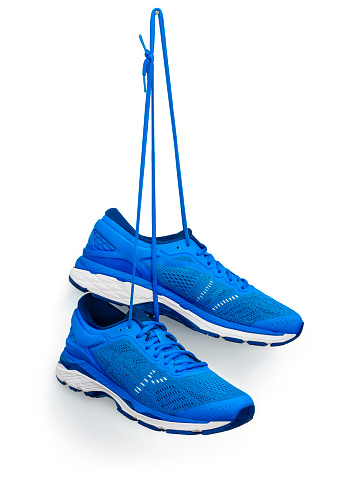 A pair of blue running shoes hanging from a hook. \nIsolated on a white background.