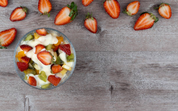 istock fruit salad in a glass plate and strawberry berries. flat layout, copy space. richest source of nutrients and vitamins. juicy and fresh berries, the concept of healthy and dietary food. 1249498718