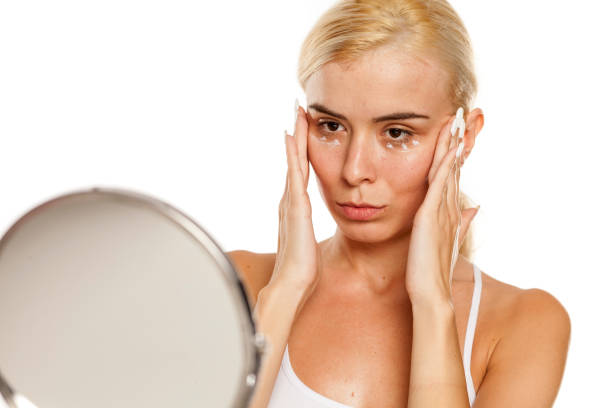 istock woman applying moisturizer on her face 1249506431