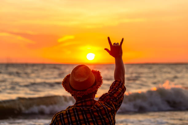 hands forming a love sign with sunset on the beach with sunset.