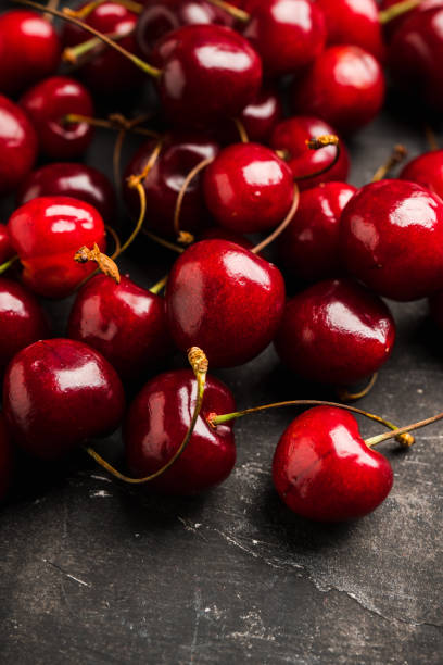 istock Ripe and juicy cherries on the dark rustic background 1249507485