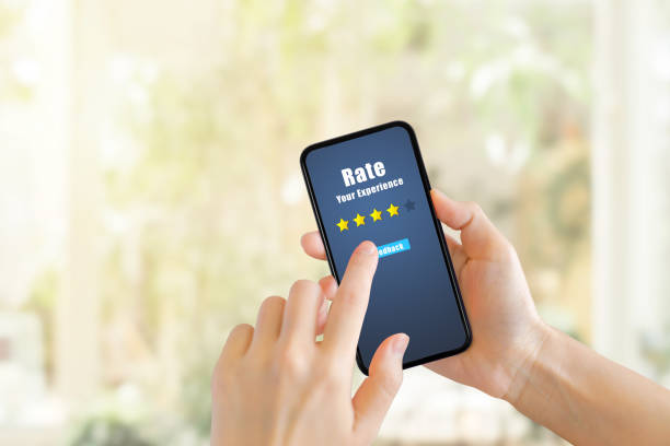 istock Hand pressing feedback button on smartphone for giving best service ranking with blurred cafe restaurant or coffee shop in background. 1249510471
