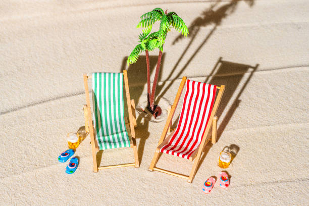 vue aérienne de deux chaises longues, transat, salon, grande tasse de bière, palmier sur la plage de sable fin. concept d’été et de voyage. minimalisme - beach tropical climate palm tree deck chair photos et images de collection