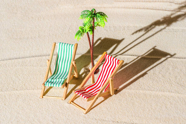 vue aérienne de deux chaises longues, transat, salon, tongs, palmier sur la plage de sable fin. concept d’été et de voyage. minimalisme - beach tropical climate palm tree deck chair photos et images de collection