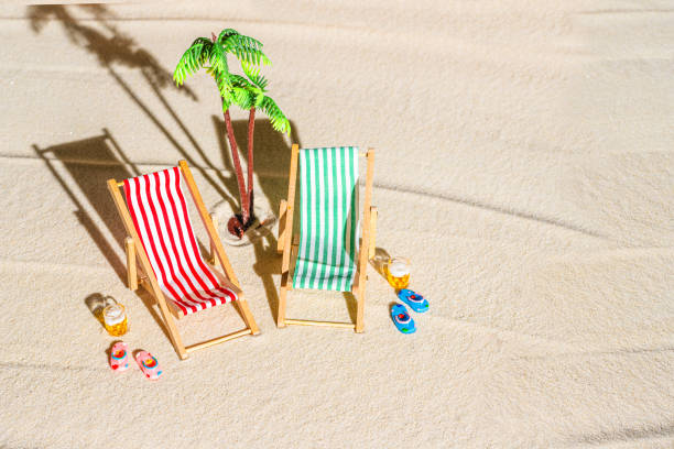 vue aérienne de deux chaises longues, transat, salon, grande tasse de bière, palmier sur la plage de sable fin. concept d’été et de voyage. minimalisme - beach tropical climate palm tree deck chair photos et images de collection