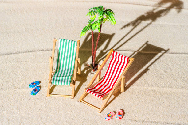 vue aérienne de deux chaises longues, transat, salon, tongs, palmier sur la plage de sable fin. concept d’été et de voyage. minimalisme - beach tropical climate palm tree deck chair photos et images de collection