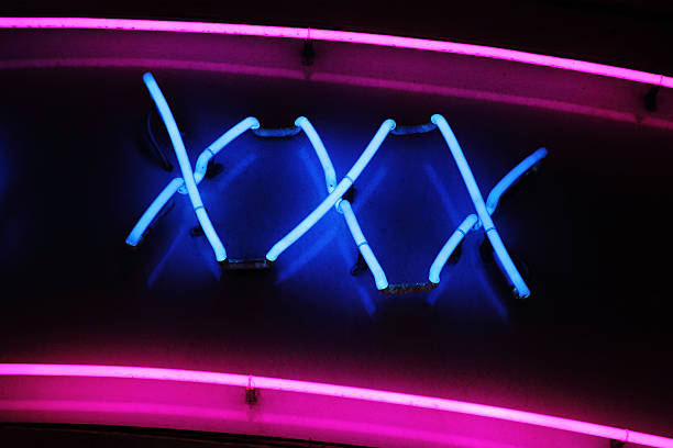 XXX Neon Sign XXX neon sign advertising an adult licensed sex shop in a red light district sleaze stock pictures, royalty-free photos & images